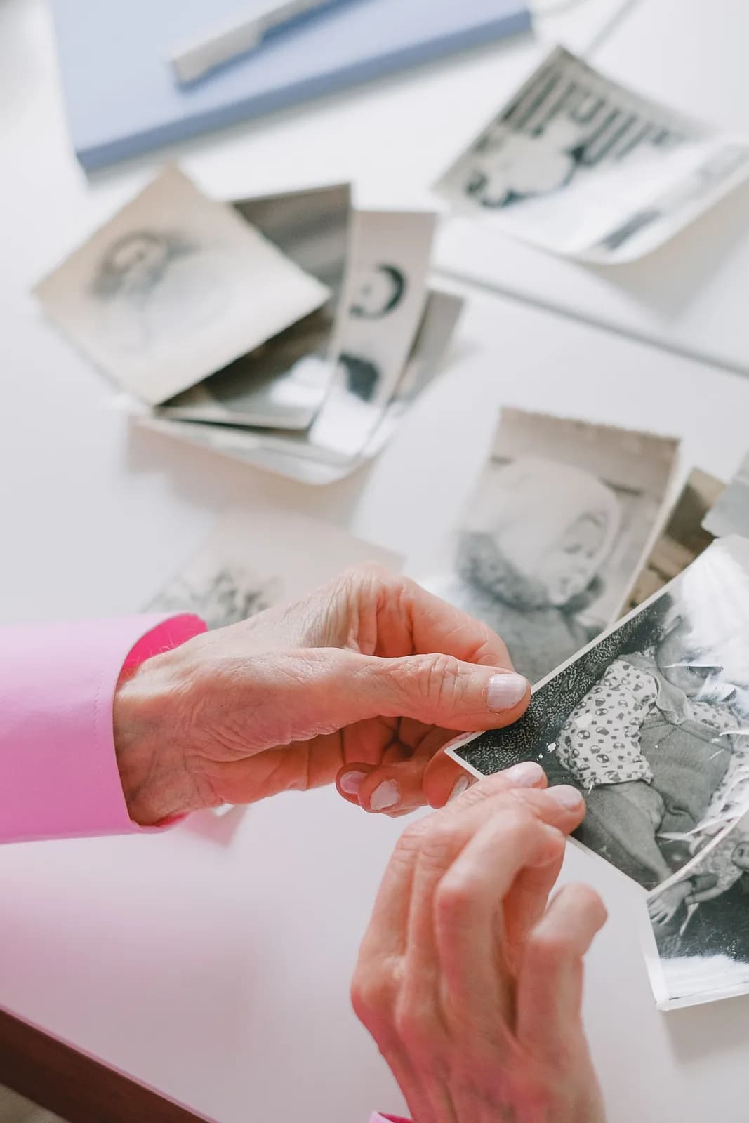 Hands looking through black-and-white print photographs