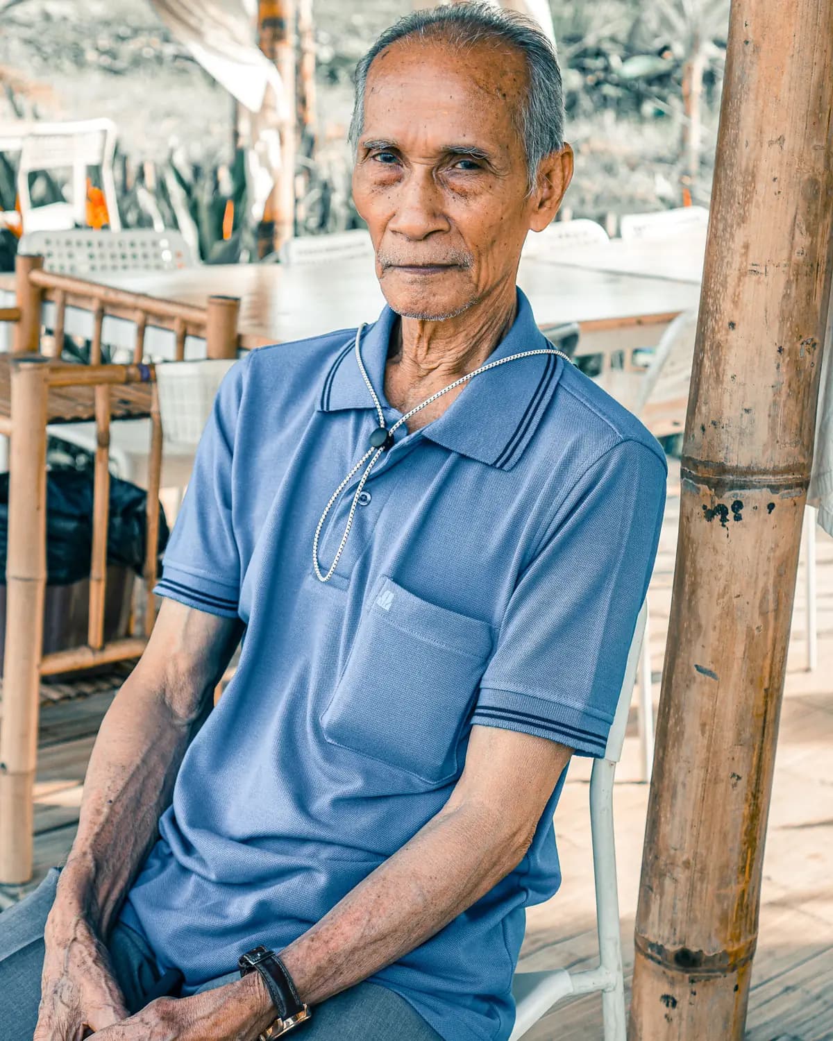 Licensed stock portrait of an older man sitting outdoors on a sunny day
